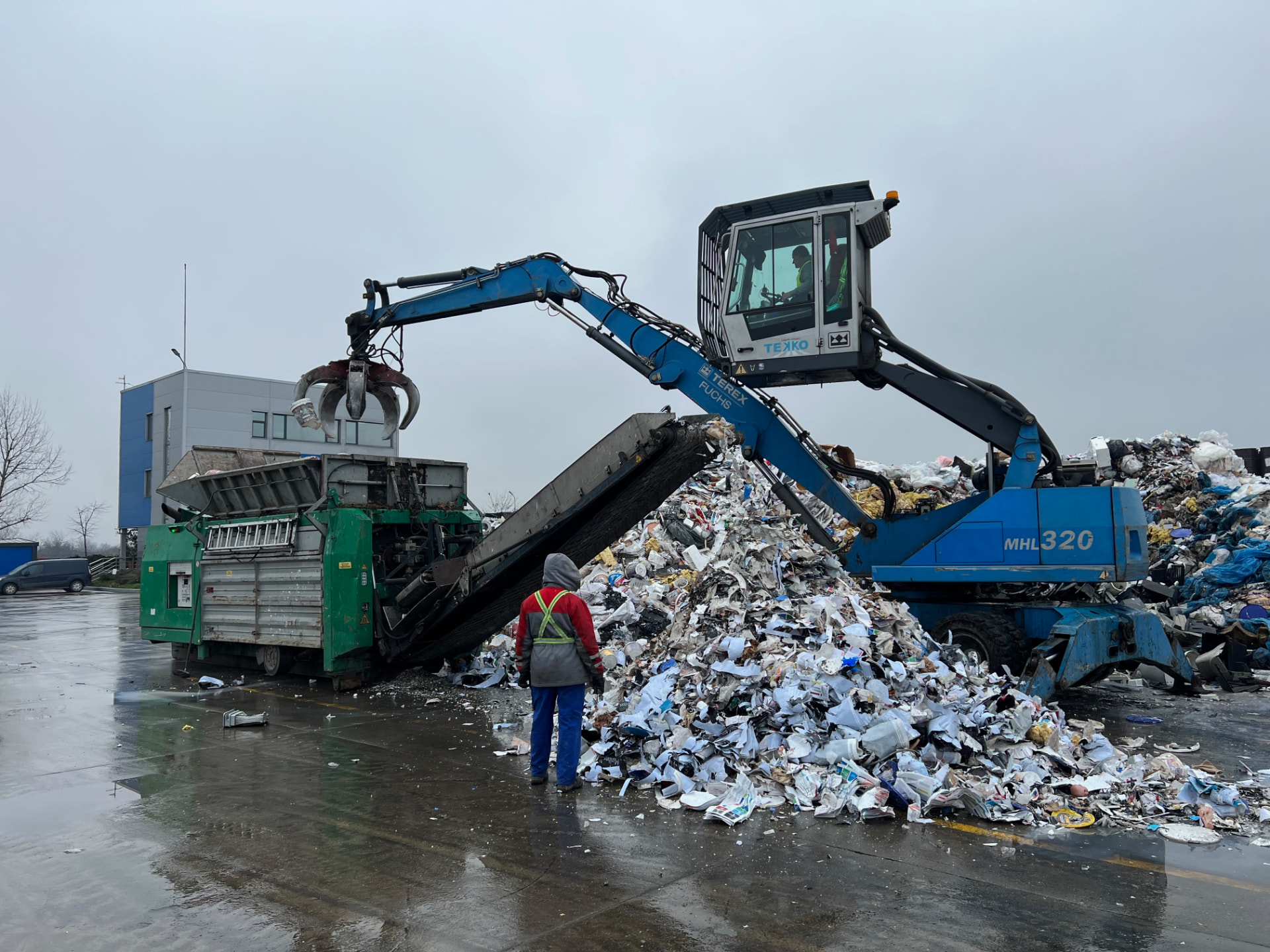 Incarcator hidraulic TEKKO care sortează materiale reciclabile în depoul de recuperare