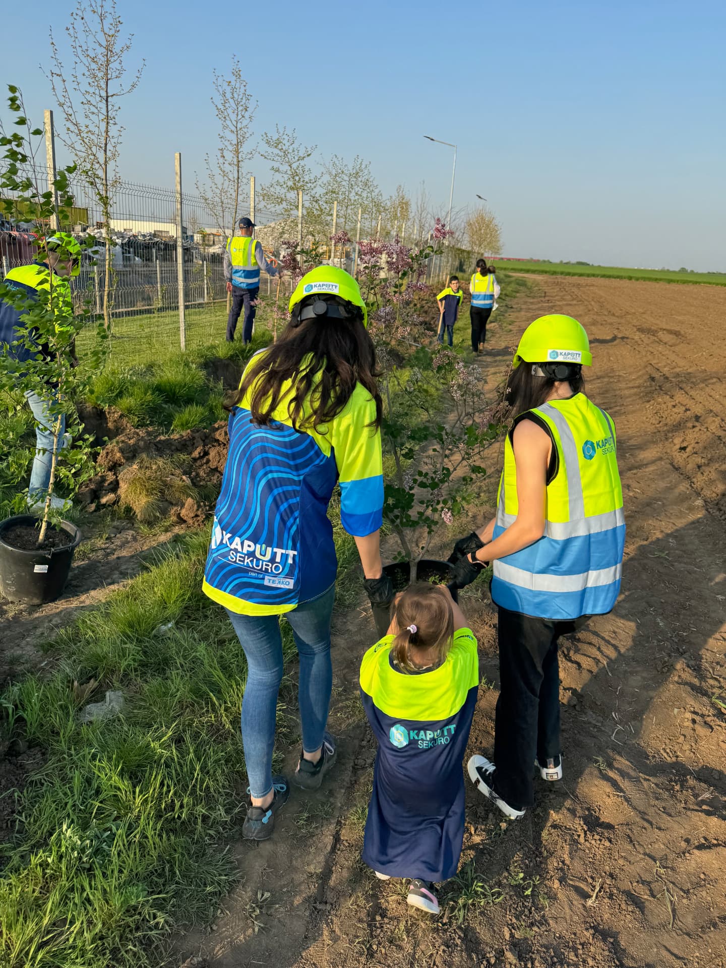 Voluntari Kaputt Sekuro plantând copaci împreună cu copiii, în România