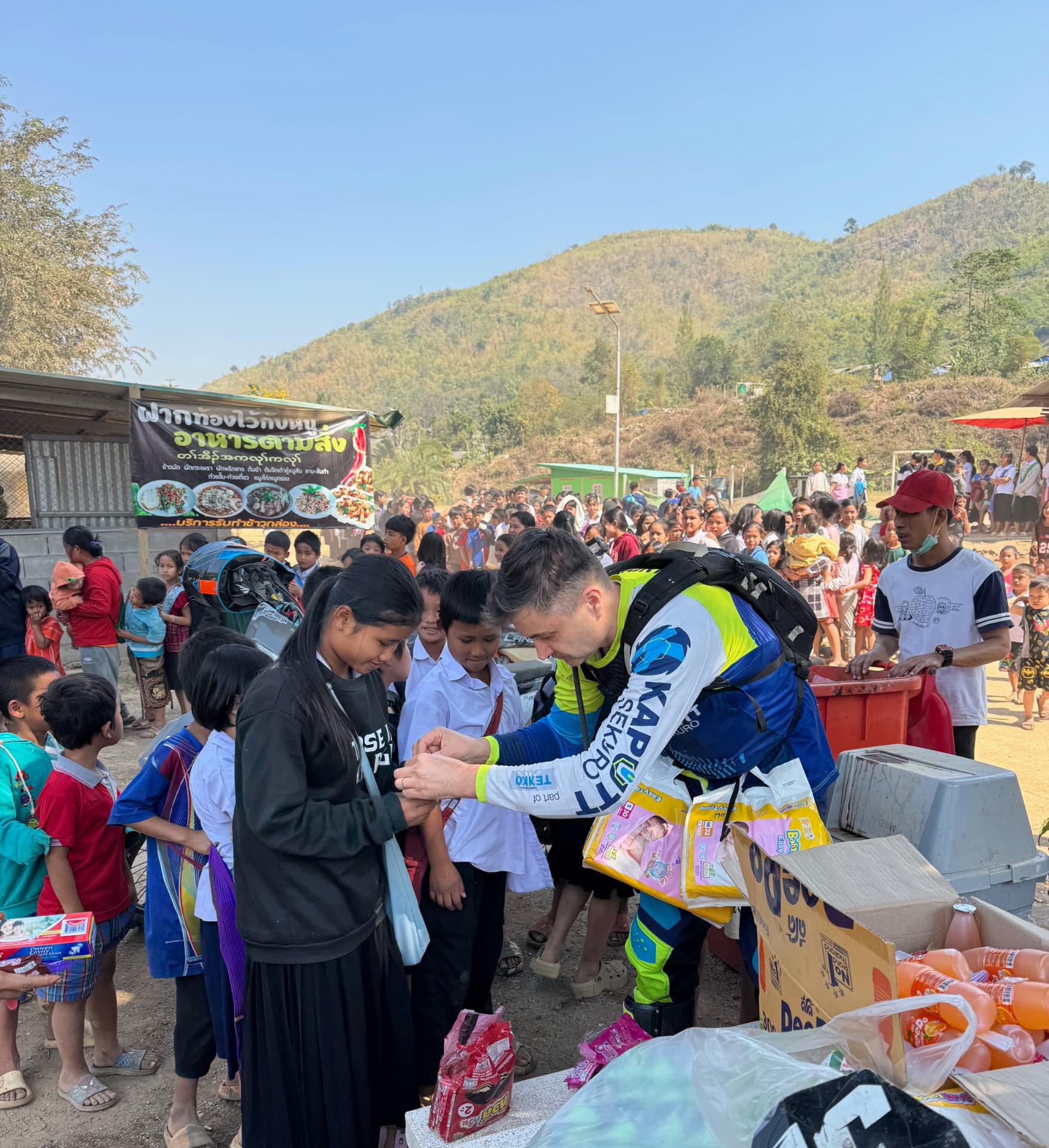 Coleg KUPELO împartind ajutoare umanitare copiilor dintr-o tabără de refugiați din Myanmar